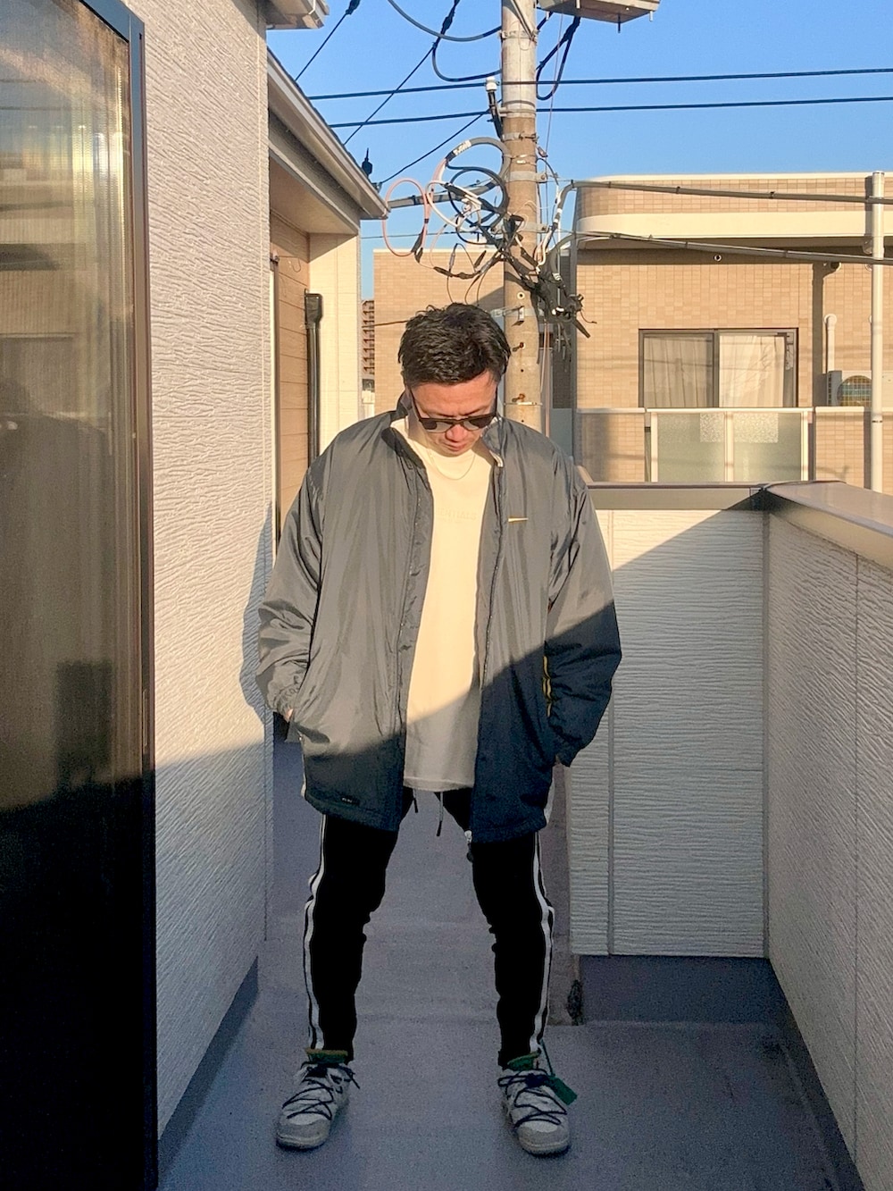 ベージュ系のスウェット、ブルー系のジャケット/アウター、ブラック系のパンツを着用したメンズの冬コーディネートの2枚目の写真