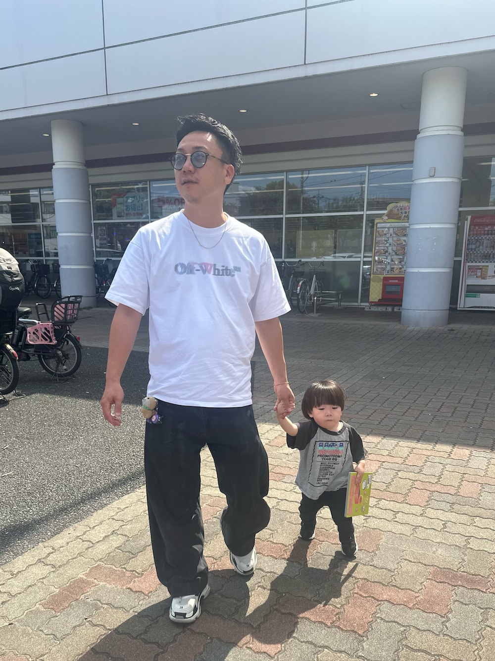 ブラック系のデニムパンツ、ブラック系のスニーカー、ホワイト系のTシャツ/カットソーを着用したメンズの秋コーディネートの5枚目の写真
