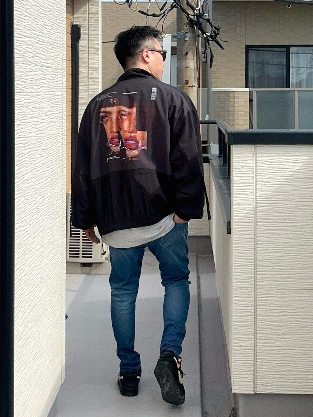 ブルー系のデニムパンツ、グレー系のTシャツ/カットソー、ブラック系のジャケット/アウターを着用したメンズの秋コーディネートの2枚目の写真