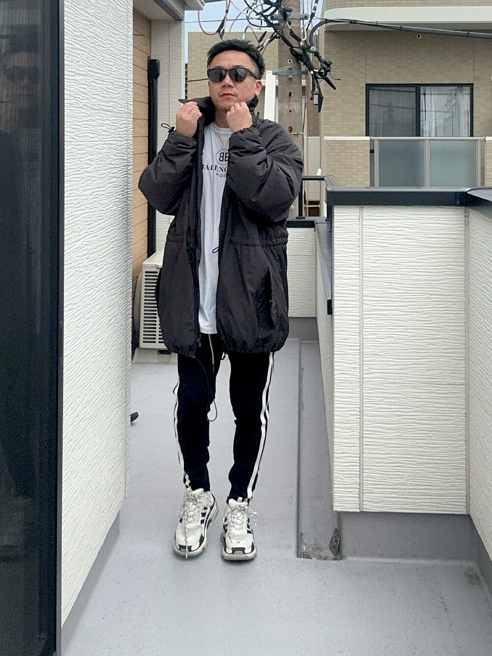 ブラック系のその他アウター、ホワイト系のTシャツ/カットソー、ブラック系のパンツを着用したメンズの秋コーディネートの4枚目の写真