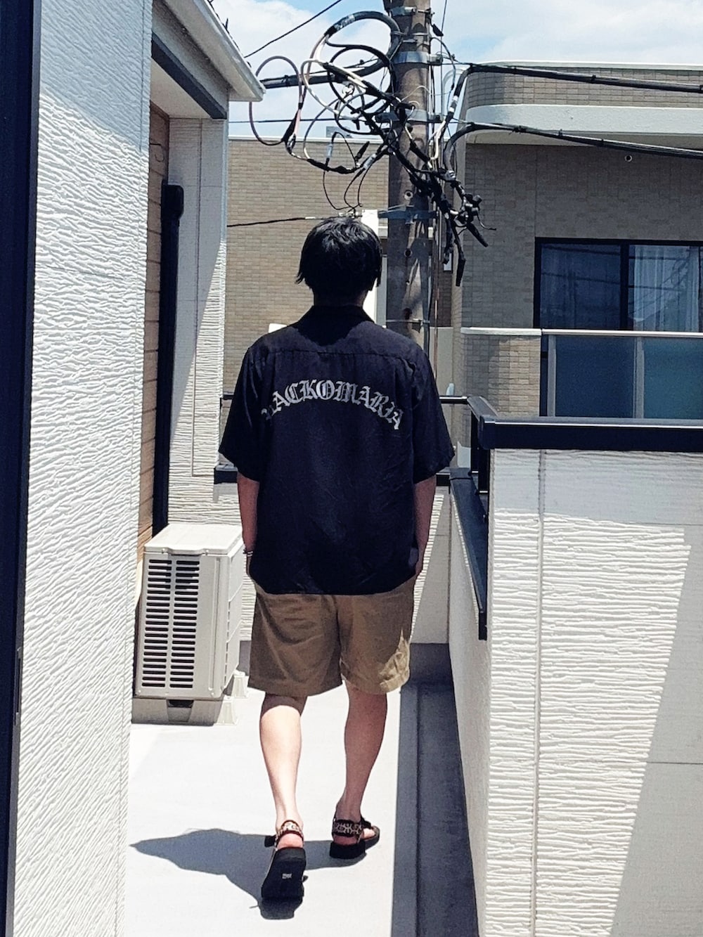 ブラック系のシャツ/ブラウス、ベージュ系のパンツ、その他のサンダルを着用したメンズの夏コーディネートの2枚目の写真