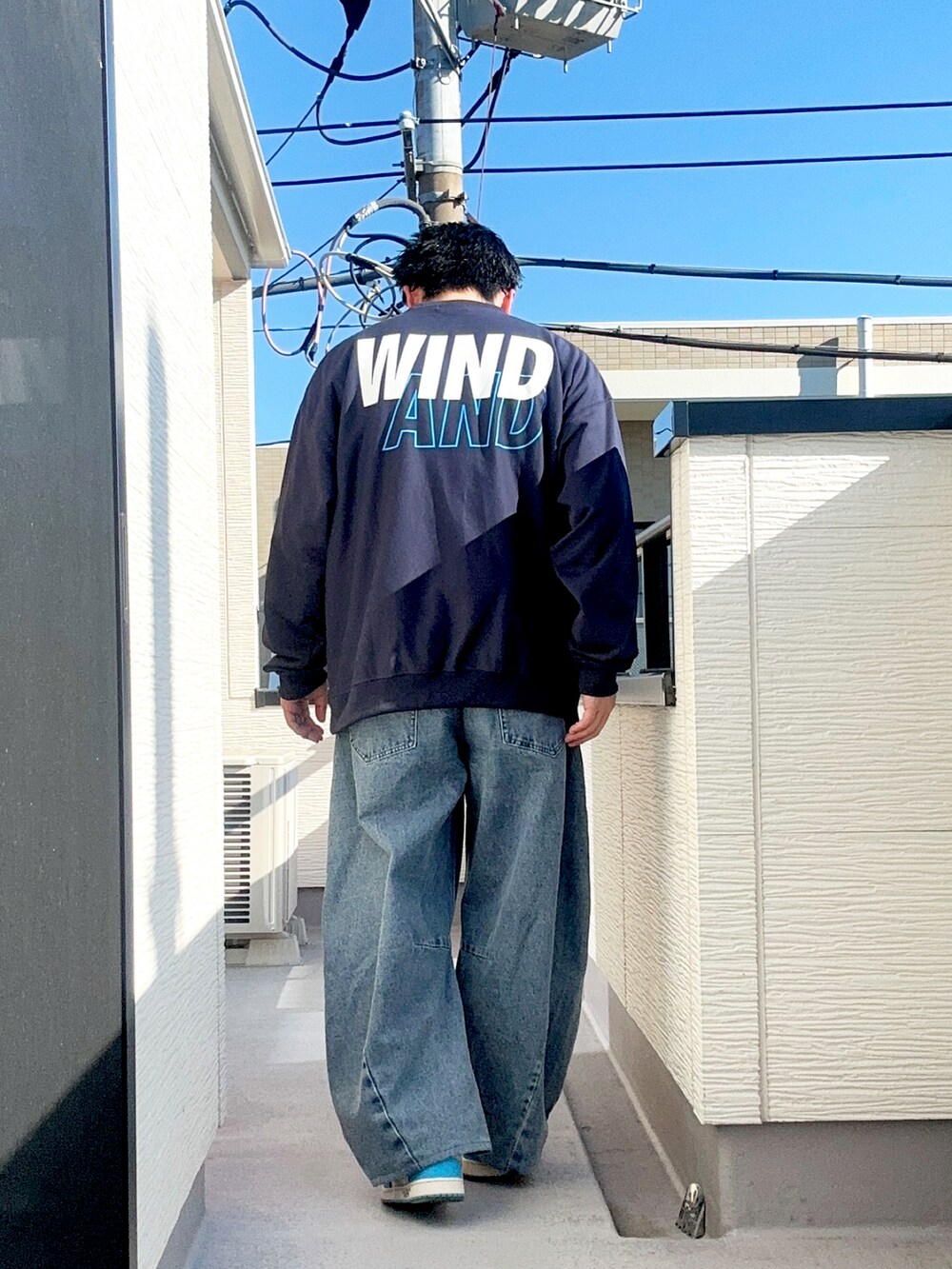 ブルー系のデニムパンツ、ベージュ系のブルゾン、ブルー系のスウェットを着用したメンズの冬コーディネートの3枚目の写真