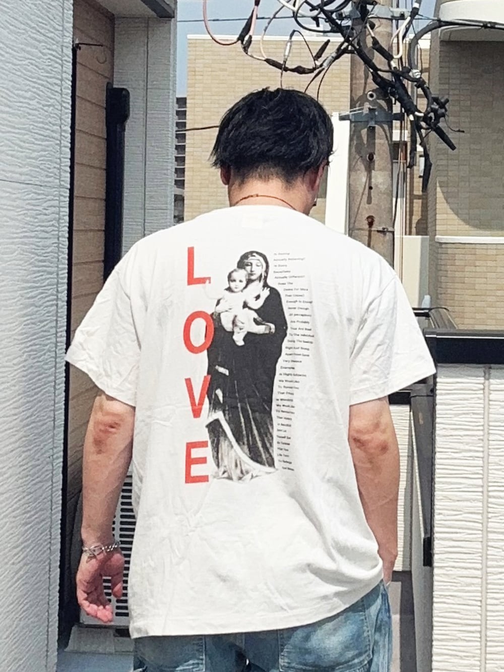 ブルー系のデニムパンツ、ホワイト系のTシャツ/カットソー、ブラウン系のローファーを着用したメンズの夏コーディネートの4枚目の写真