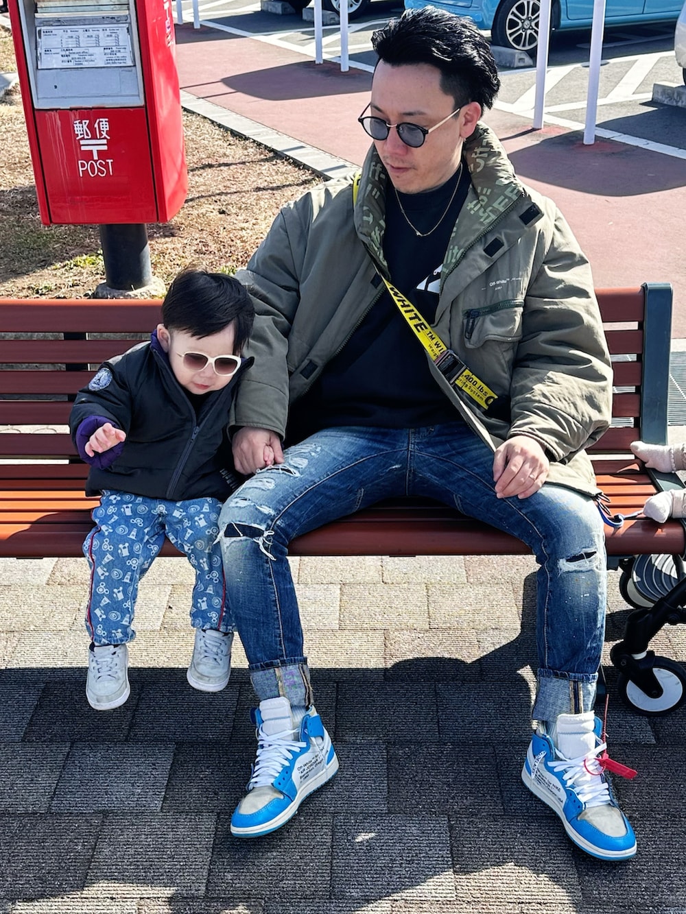 ブルー系のデニムパンツ、ブラック系のショルダーバッグ、ブラック系のスウェットを着用したメンズの冬コーディネートの2枚目の写真