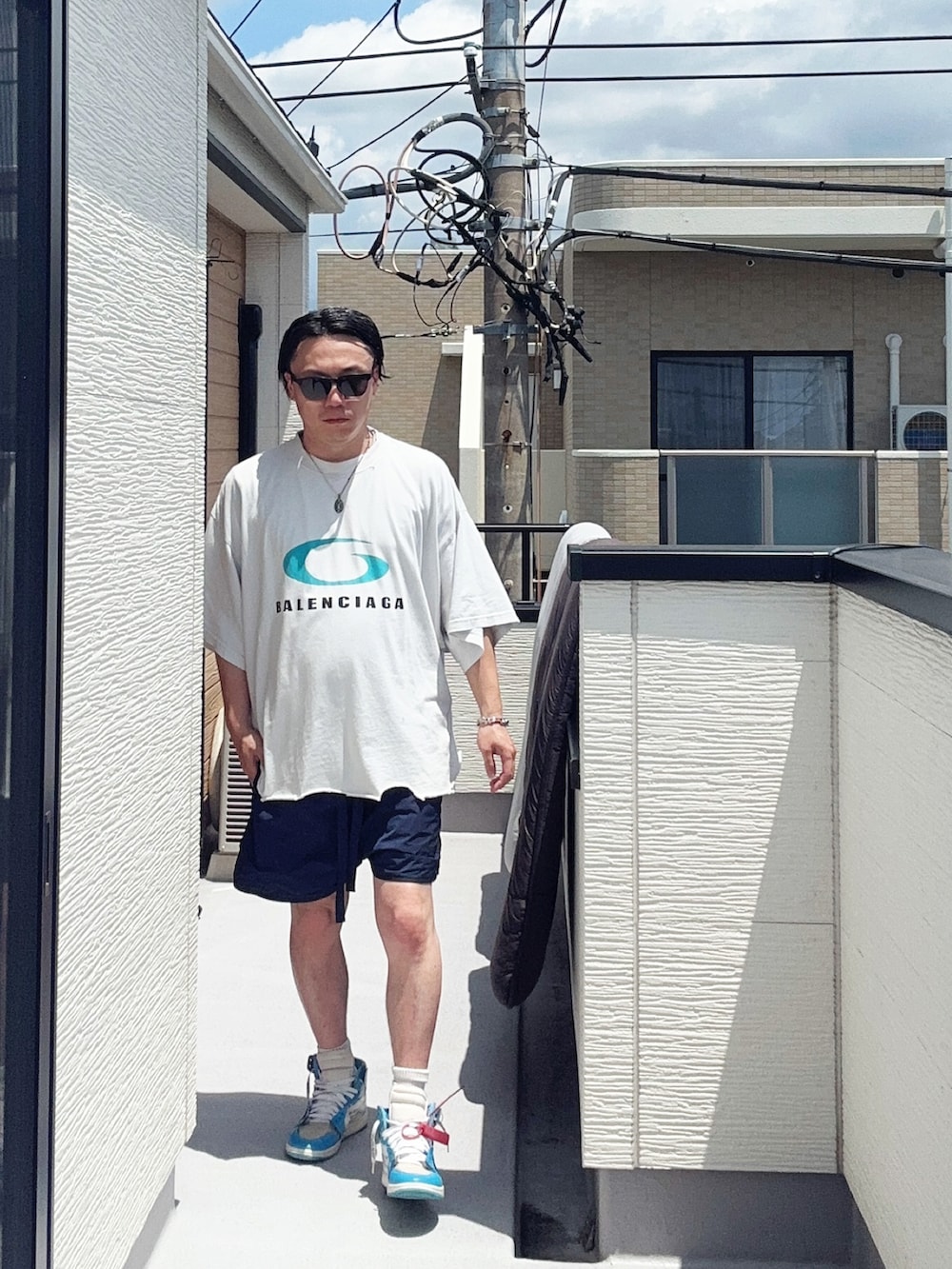 ホワイト系のTシャツ/カットソー、ブルー系のパンツ、ブルー系のスニーカーを着用したメンズの夏コーディネートの2枚目の写真