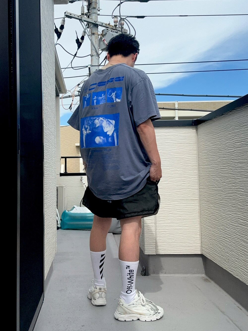 ブルー系のTシャツ/カットソー、ブラック系のパンツ、ホワイト系のスニーカーを着用したメンズの夏コーディネートの2枚目の写真