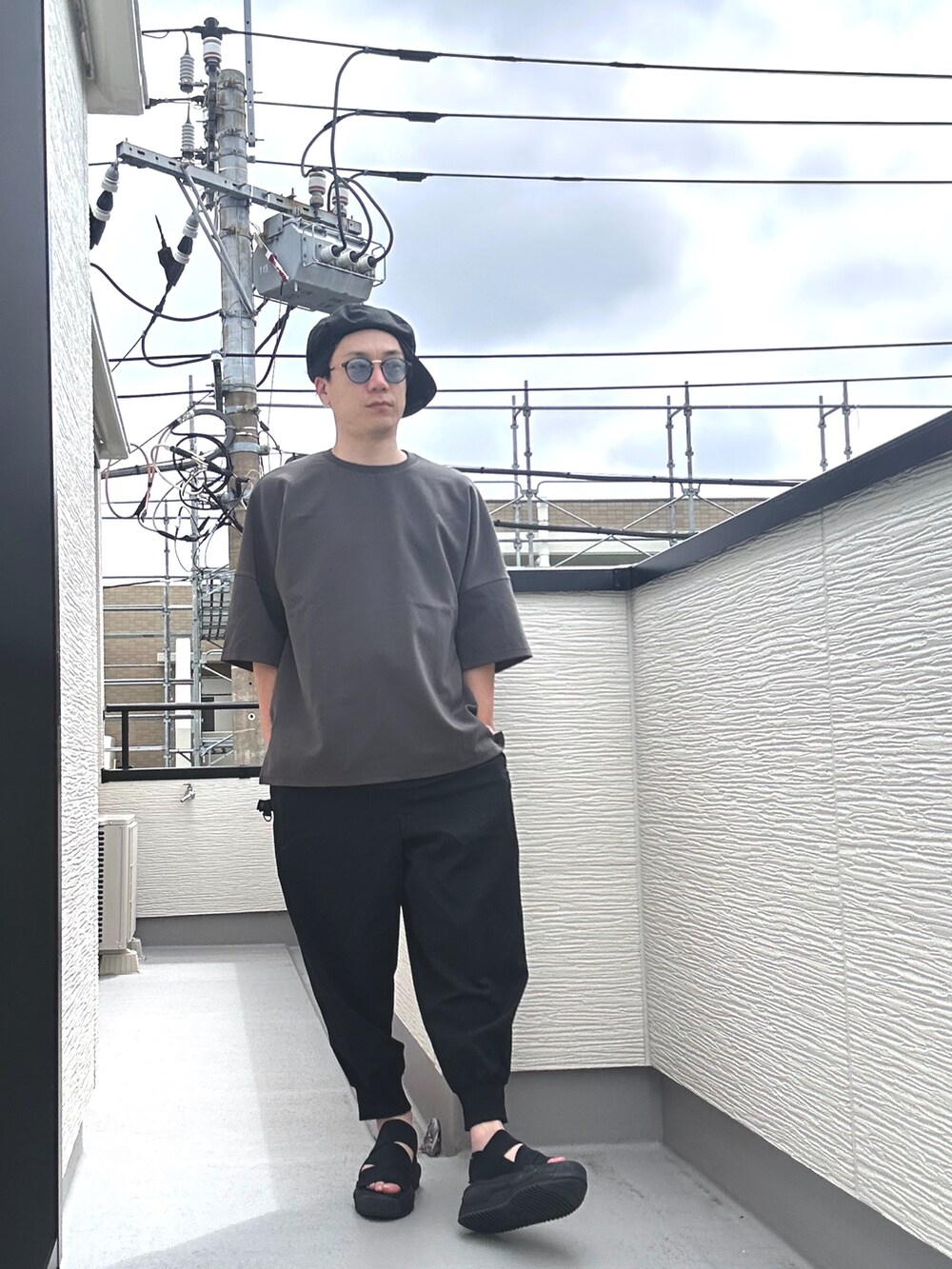 グレー系のTシャツ/カットソー、ブラック系のその他パンツ、ブラック系のサンダルを着用したメンズの夏コーディネートの2枚目の写真