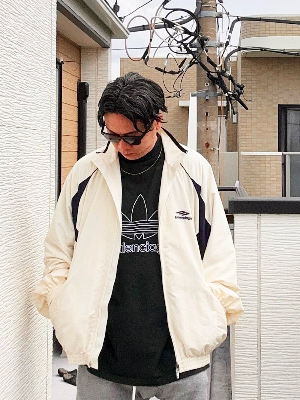グリーン系のTシャツ/カットソー、ホワイト系のナイロンジャケット、グレー系のパンツを着用したメンズの秋コーディネートの2枚目の写真