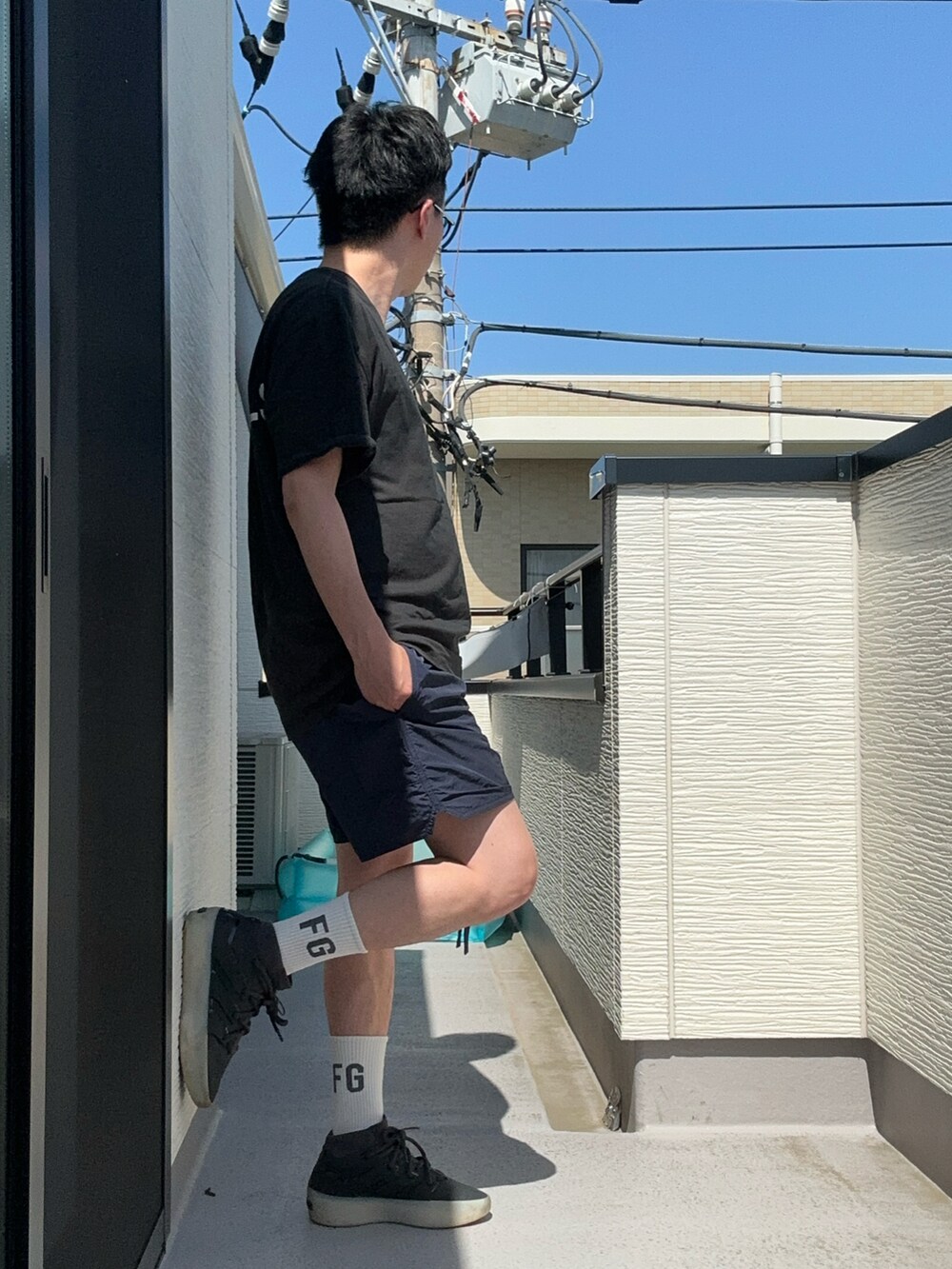 ブルー系のパンツ、ブラック系のTシャツ/カットソー、ブラック系のスニーカーを着用したメンズの夏コーディネートの4枚目の写真