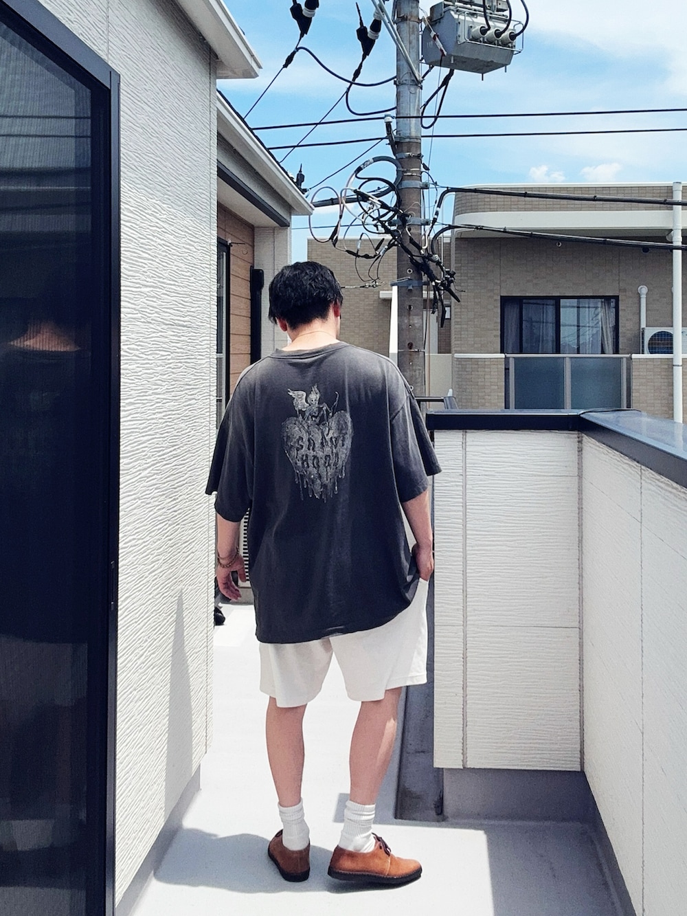 ブラック系のTシャツ/カットソー、ホワイト系のパンツ、ブラウン系のドレスシューズを着用したメンズの夏コーディネートの3枚目の写真