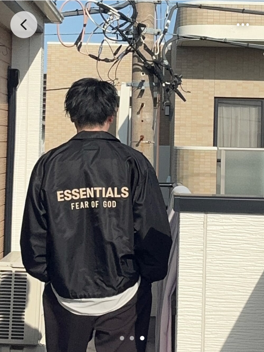 ブラック系のナイロンジャケット、ブラック系のスラックス、ホワイト系のTシャツ/カットソーを着用したメンズの春コーディネートの2枚目の写真