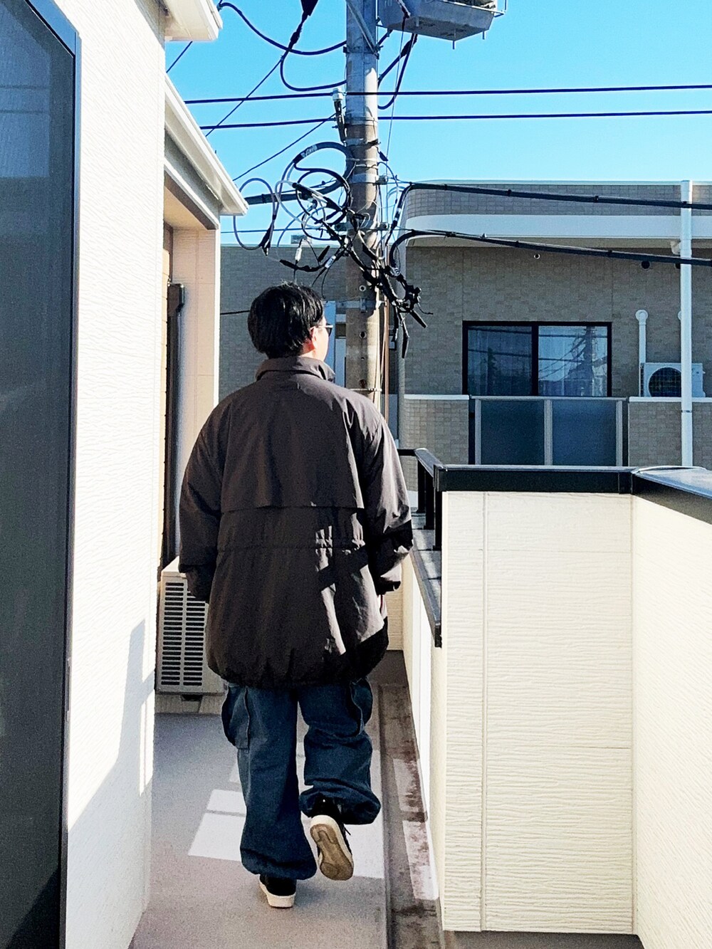 グレー系のTシャツ/カットソー、ブラック系のその他アウター、ブルー系のカーゴパンツを着用したメンズの秋コーディネートの3枚目の写真