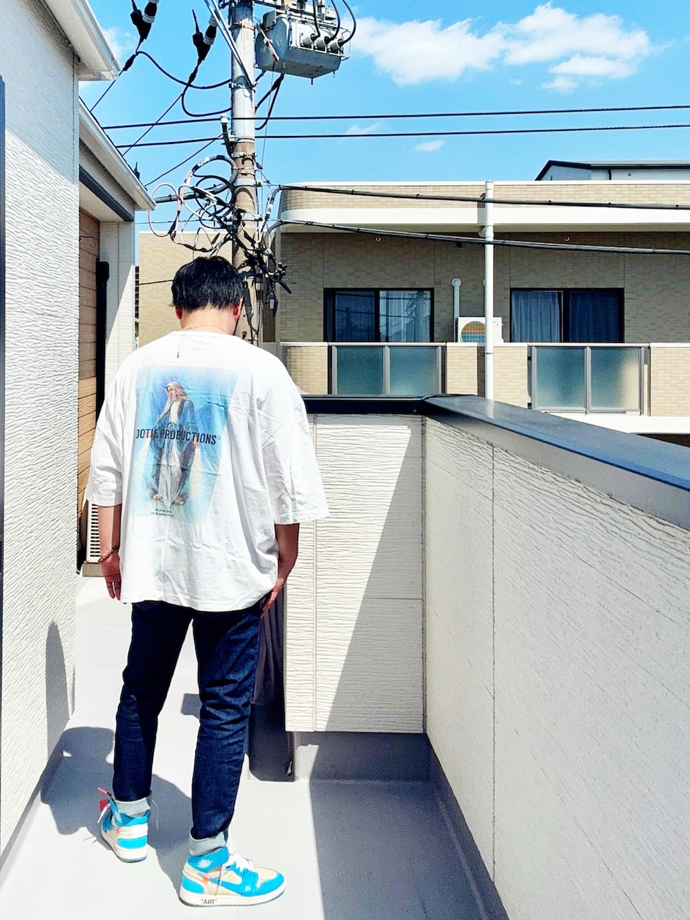ホワイト系のTシャツ/カットソー、ブルー系のデニムパンツ、ブルー系のスニーカーを着用したメンズの春コーディネートの4枚目の写真