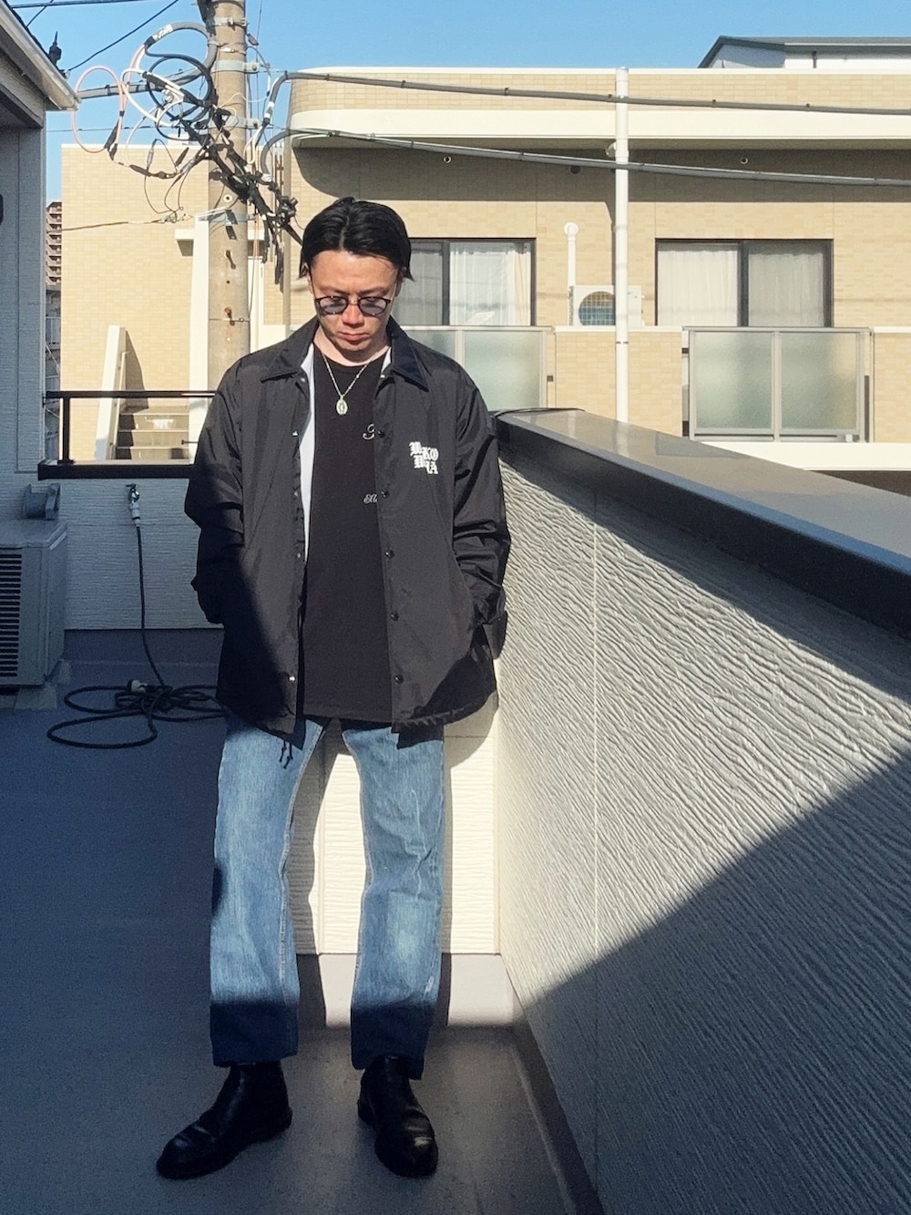 ブルー系のデニムパンツ、ブラック系のTシャツ/カットソー、ブラック系のジャケット/アウターを着用したメンズの春コーディネートの2枚目の写真