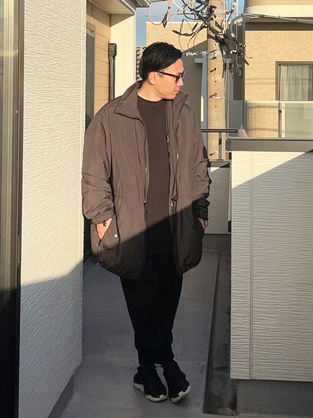 ブラック系のスウェット、ブラック系のその他アウター、ブラック系のスニーカーを着用したメンズの冬コーディネートの3枚目の写真