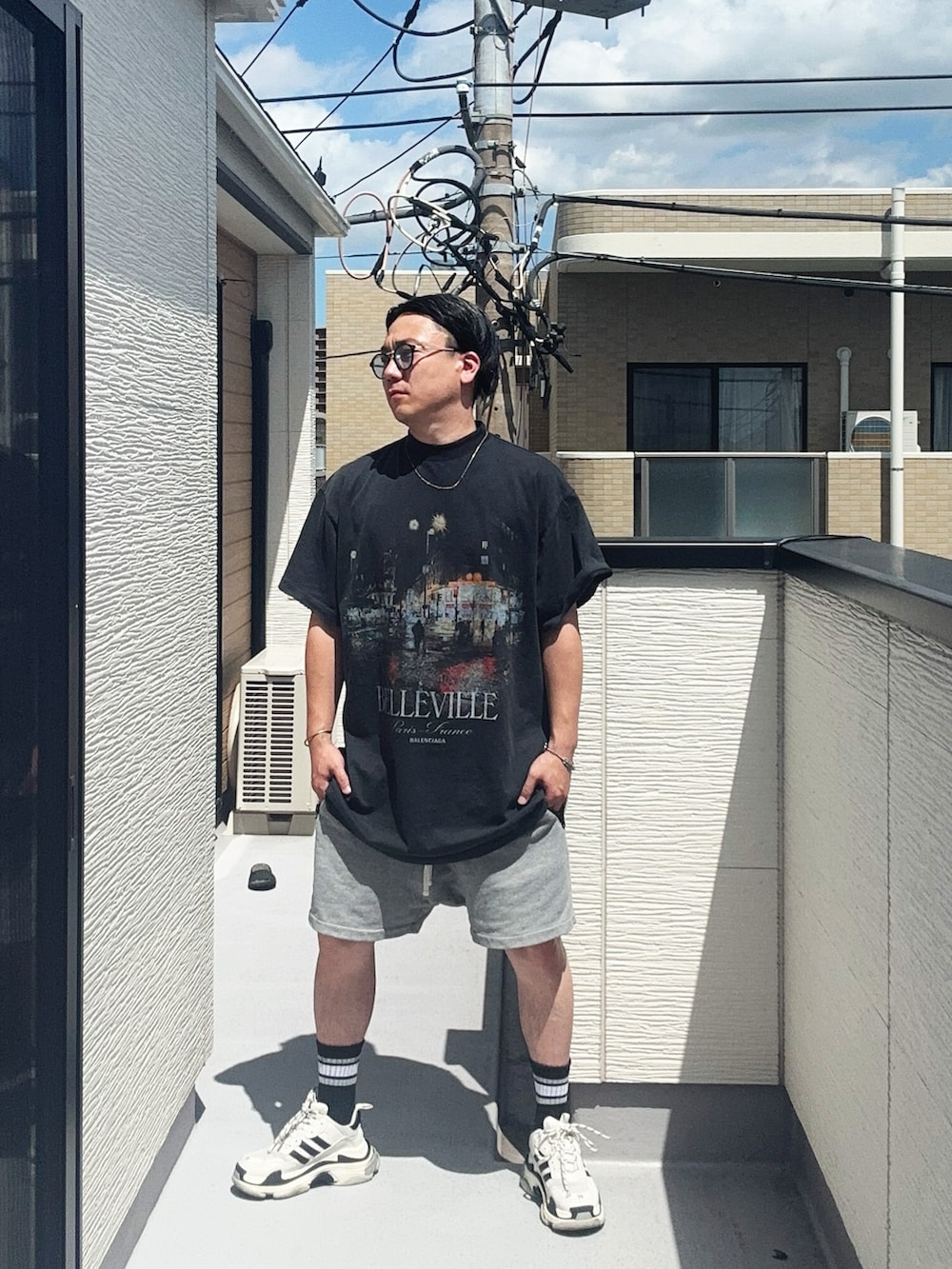 ブラック系のTシャツ/カットソー、グレー系のパンツ、ホワイト系のシューズを着用したメンズの夏コーディネートの3枚目の写真