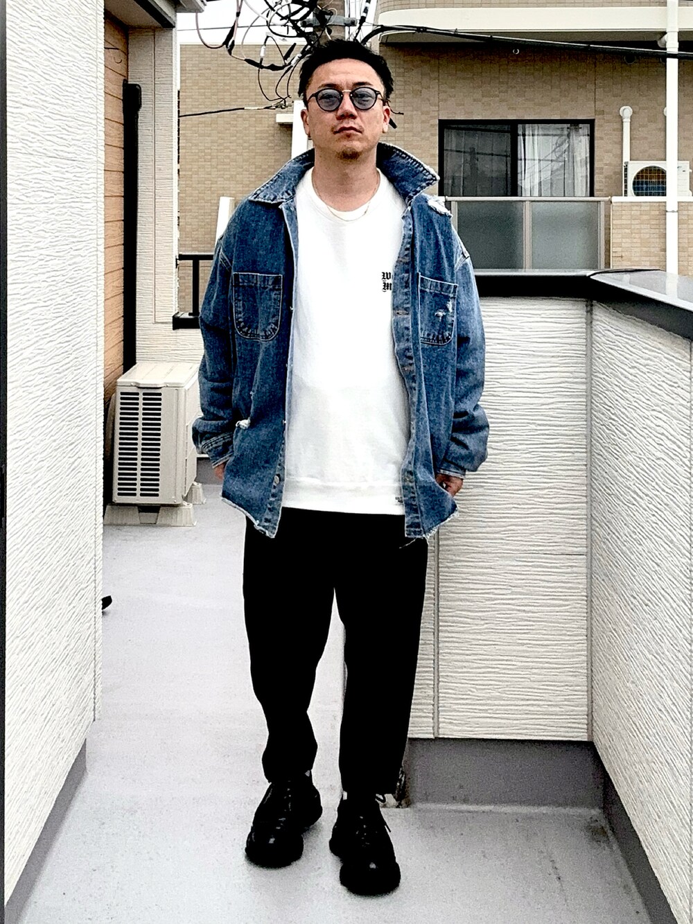 ブラック系のスラックス、ホワイト系のスウェット、ブルー系のデニムジャケットを着用したメンズの秋コーディネートの3枚目の写真