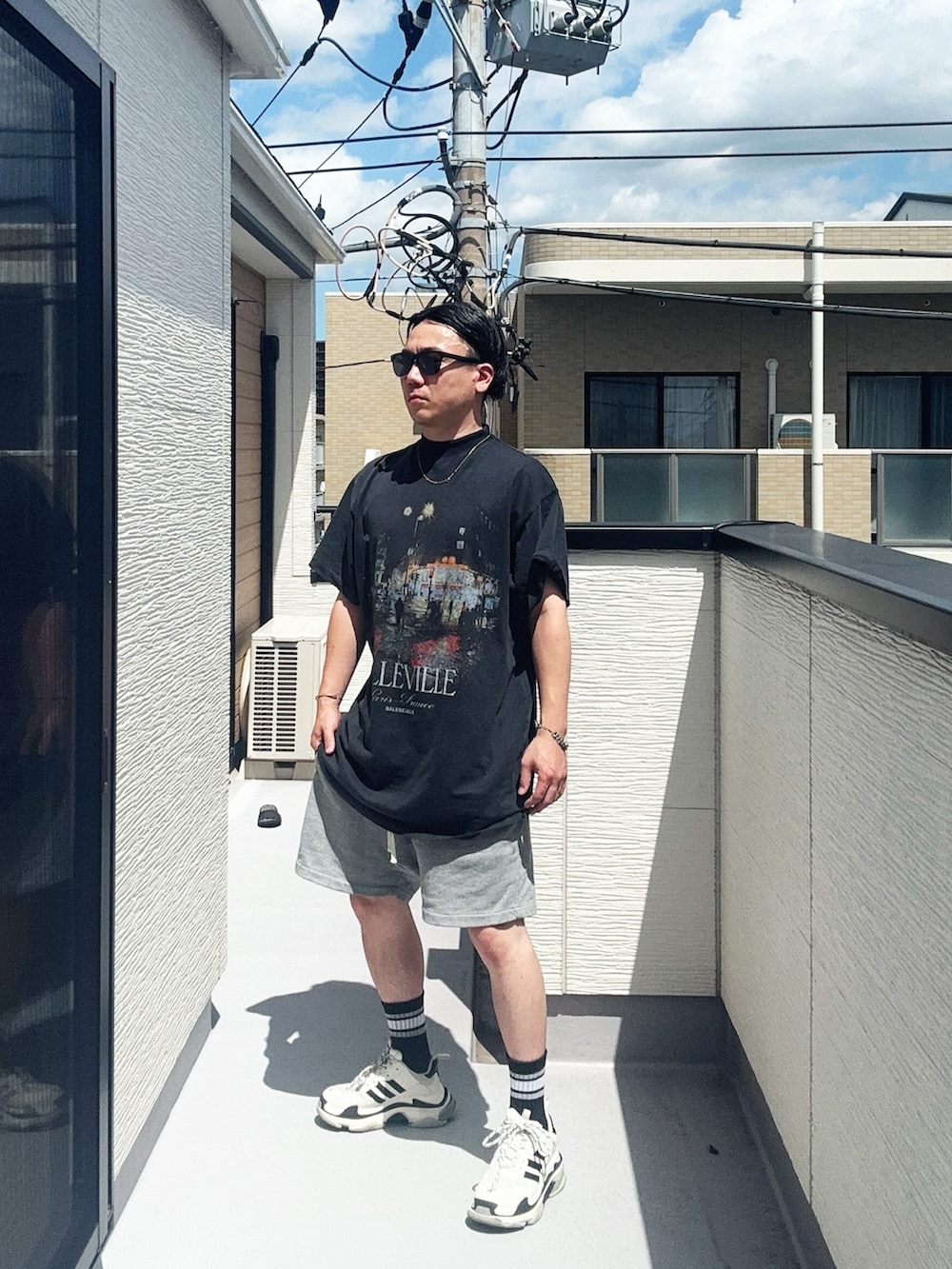 ブラック系のTシャツ/カットソー、グレー系のパンツ、ホワイト系のシューズを着用したメンズの夏コーディネートの4枚目の写真