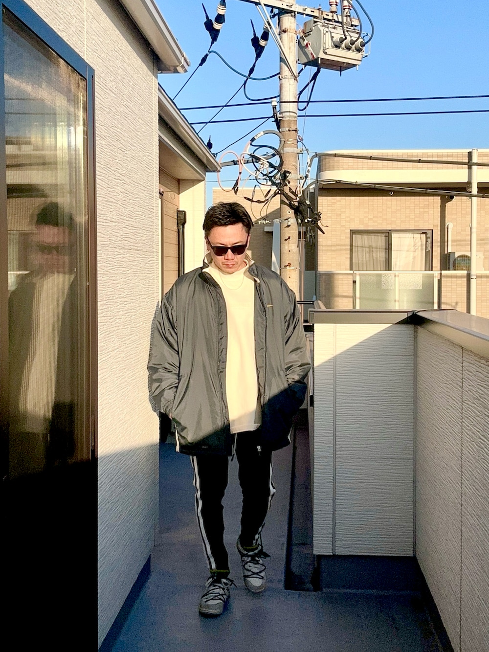 ベージュ系のスウェット、ブルー系のジャケット/アウター、ブラック系のパンツを着用したメンズの冬コーディネートの3枚目の写真