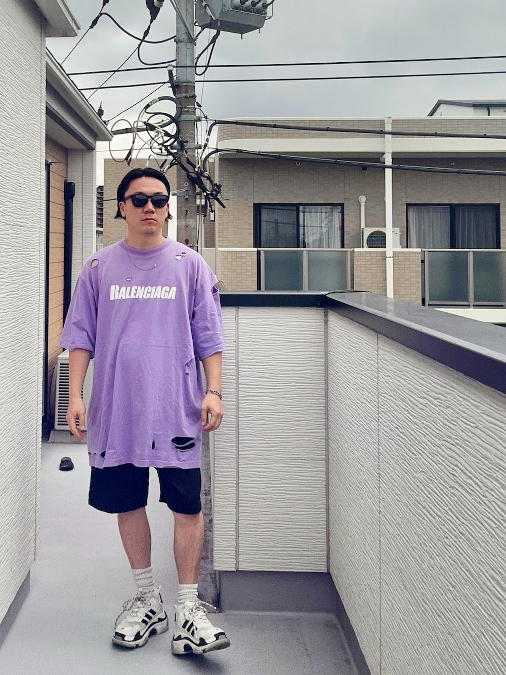 パープル系のTシャツ/カットソー、ブラック系のパンツ、ホワイト系のシューズを着用したメンズの秋コーディネートの2枚目の写真