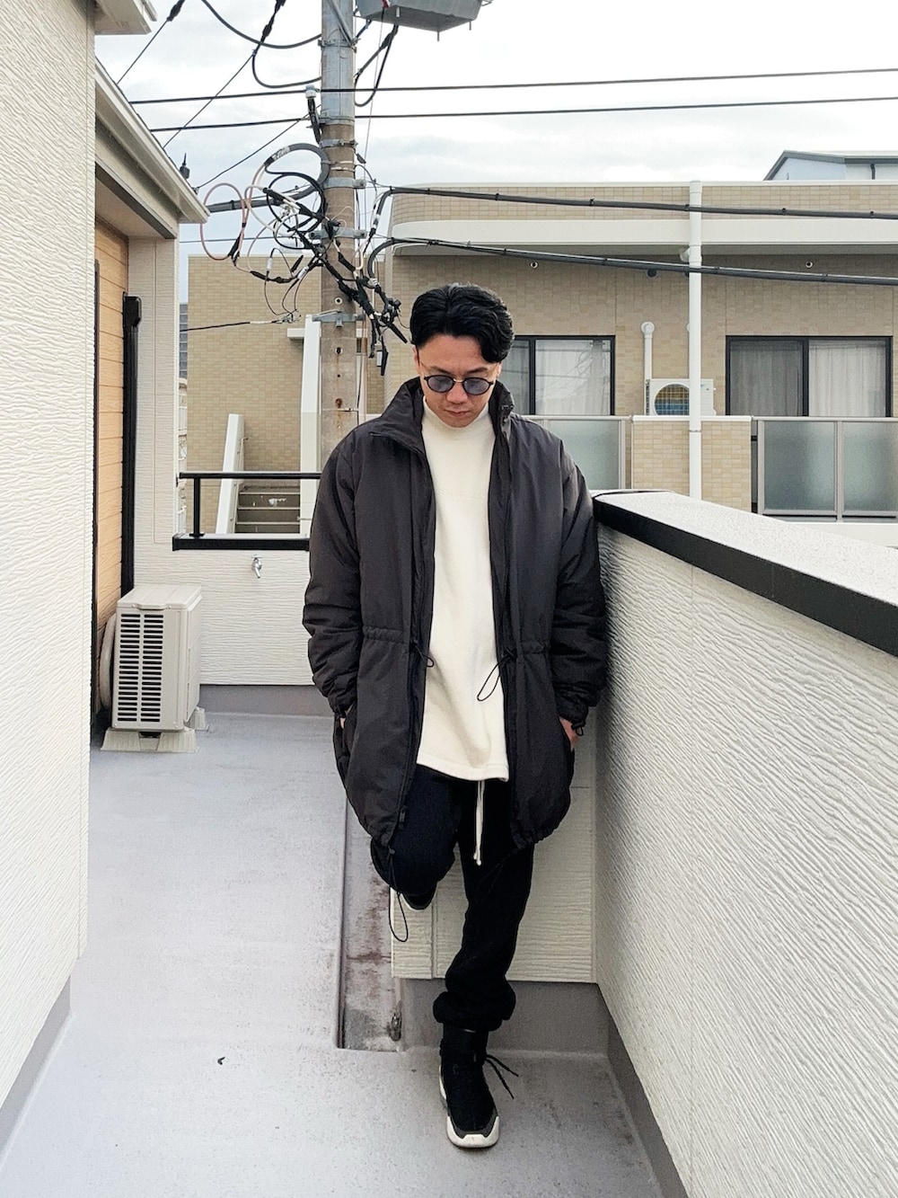 ベージュ系のスウェット、ブラック系のその他アウター、ブラック系のスウェットパンツを着用したメンズの秋コーディネートの2枚目の写真