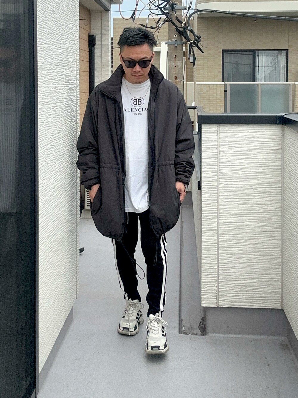 ブラック系のその他アウター、ホワイト系のTシャツ/カットソー、ブラック系のパンツを着用したメンズの秋コーディネートの3枚目の写真
