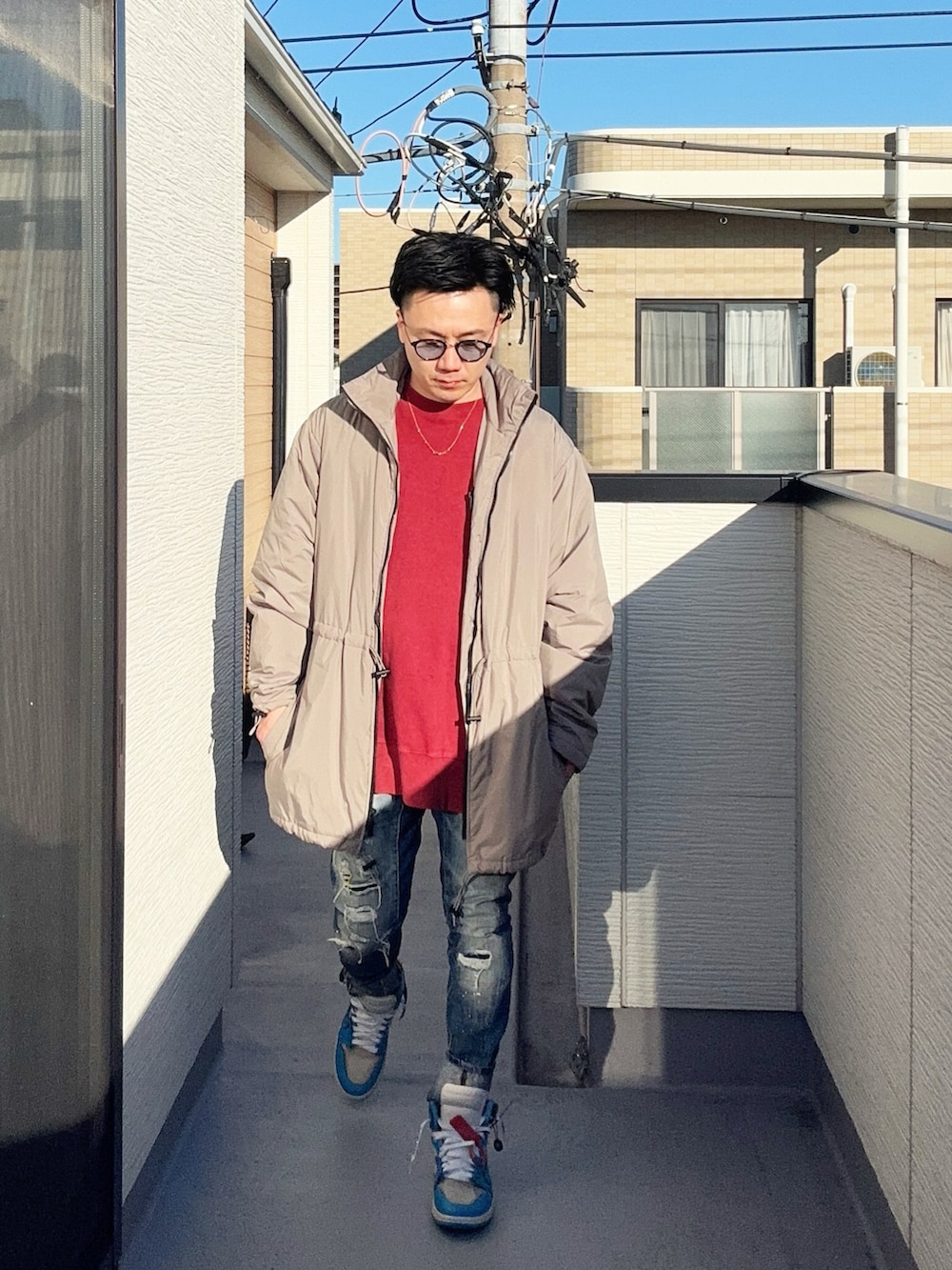 レッド系のスウェット、ベージュ系のその他アウター、ブルー系のデニムパンツを着用したメンズの冬コーディネートの3枚目の写真