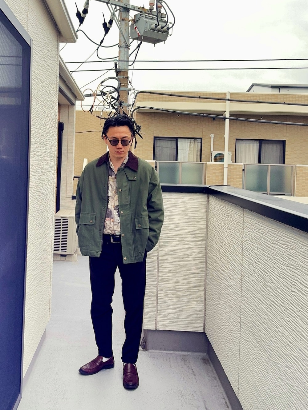 ベージュ系のシャツ/ブラウス、グリーン系のミリタリージャケット、ブラック系のスラックスを着用したメンズの春コーディネートの2枚目の写真