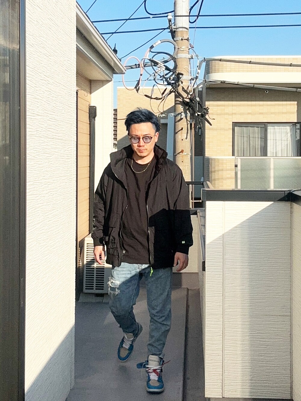 ブルー系のデニムパンツ、ブラック系のTシャツ/カットソー、ブラック系のブルゾンを着用したメンズの冬コーディネートの2枚目の写真