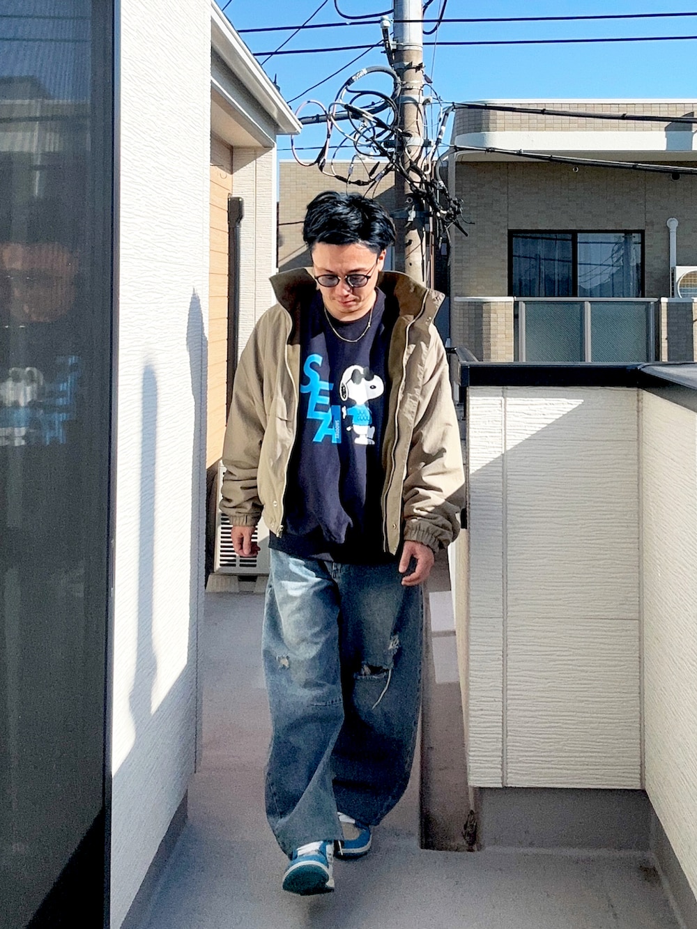 ブルー系のデニムパンツ、ベージュ系のブルゾン、ブルー系のスウェットを着用したメンズの冬コーディネートの2枚目の写真