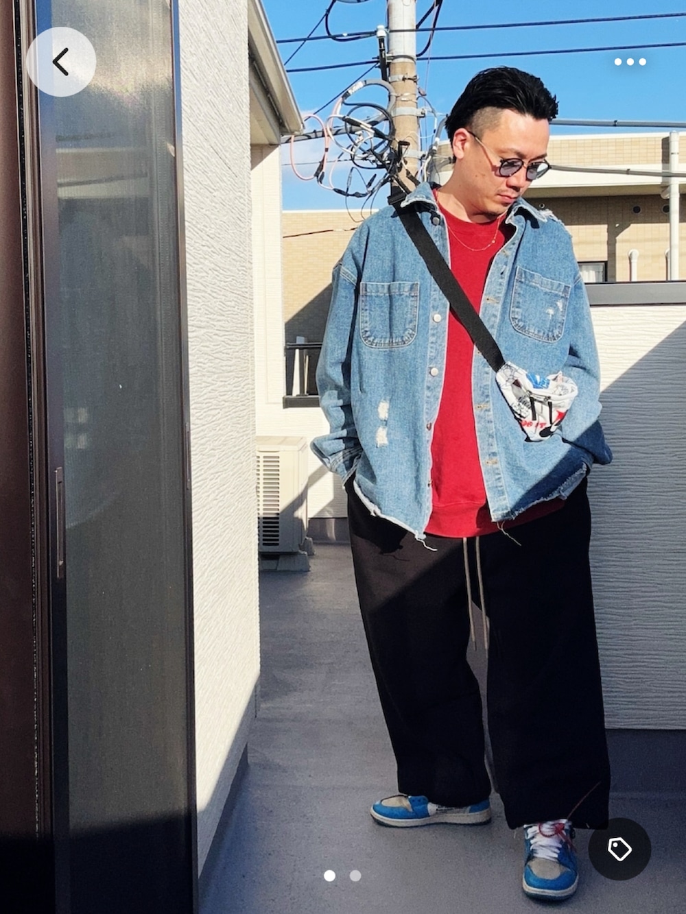 レッド系のスウェット、ブラック系のスウェットパンツ、ブルー系のデニムジャケットを着用したメンズの冬コーディネートの2枚目の写真