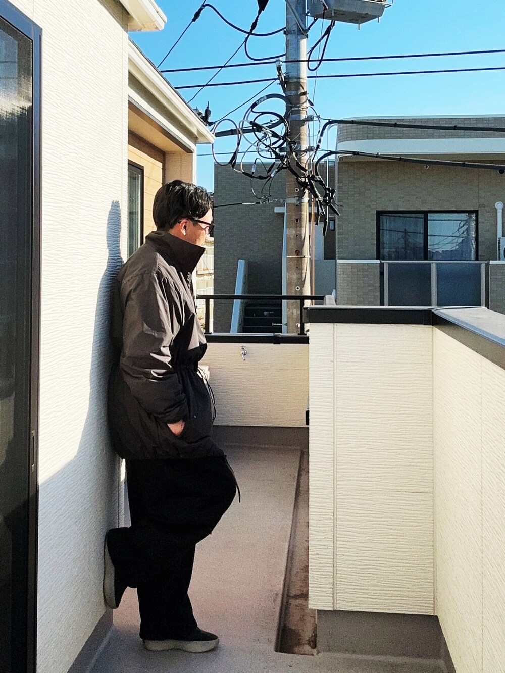 ブラック系のその他アウター、ホワイト系のニット/セーター、ブラック系のスウェットパンツを着用したメンズの冬コーディネートの3枚目の写真