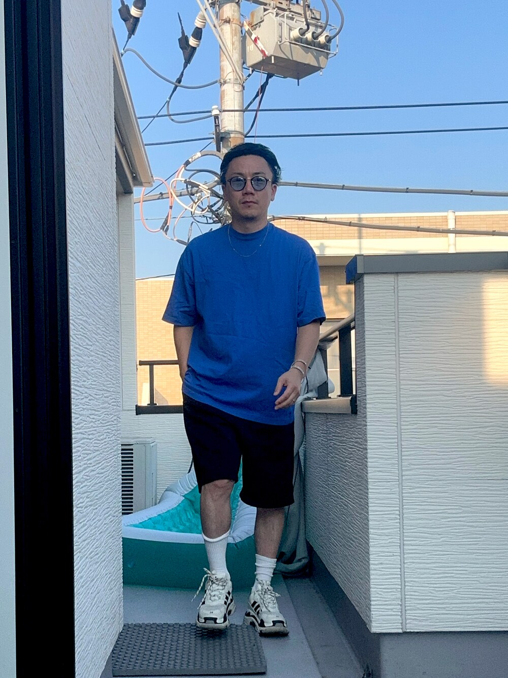 ブルー系のTシャツ/カットソー、ブラック系のスウェットパンツ、ホワイト系のシューズを着用したメンズの秋コーディネートの2枚目の写真