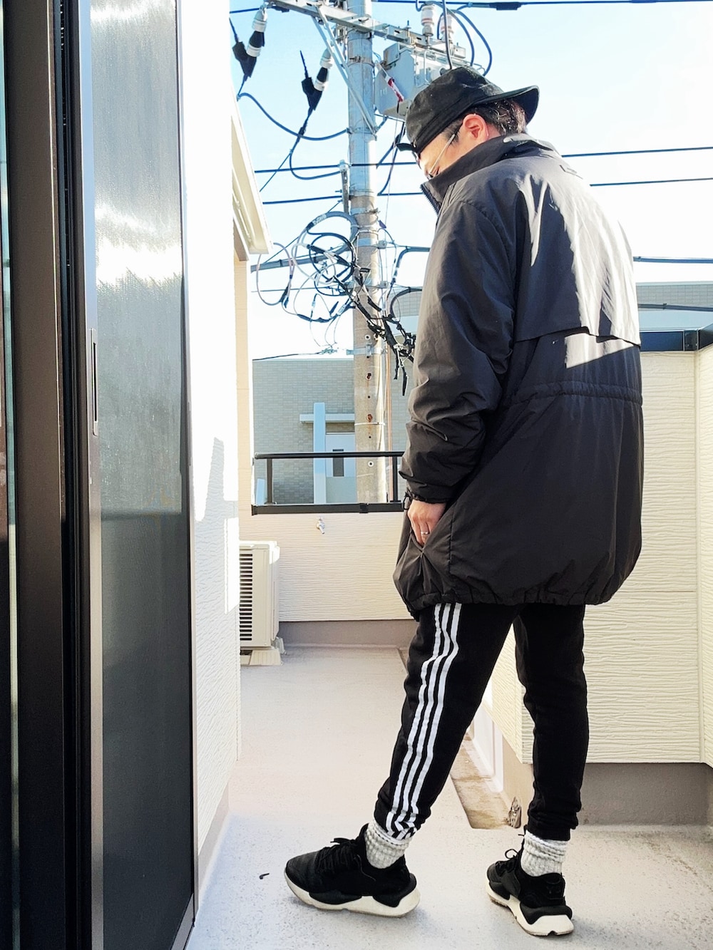 ブラック系のスウェット、ブラック系のスウェットパンツ、ブラック系のスニーカーを着用したメンズの冬コーディネートの2枚目の写真