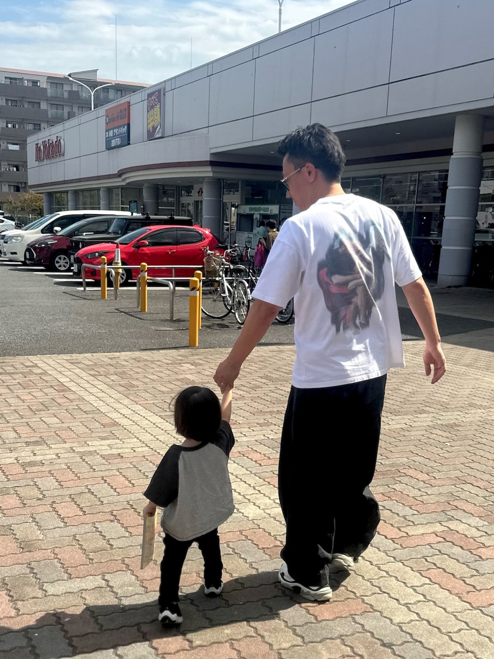 ブラック系のデニムパンツ、ブラック系のスニーカー、ホワイト系のTシャツ/カットソーを着用したメンズの秋コーディネートの4枚目の写真