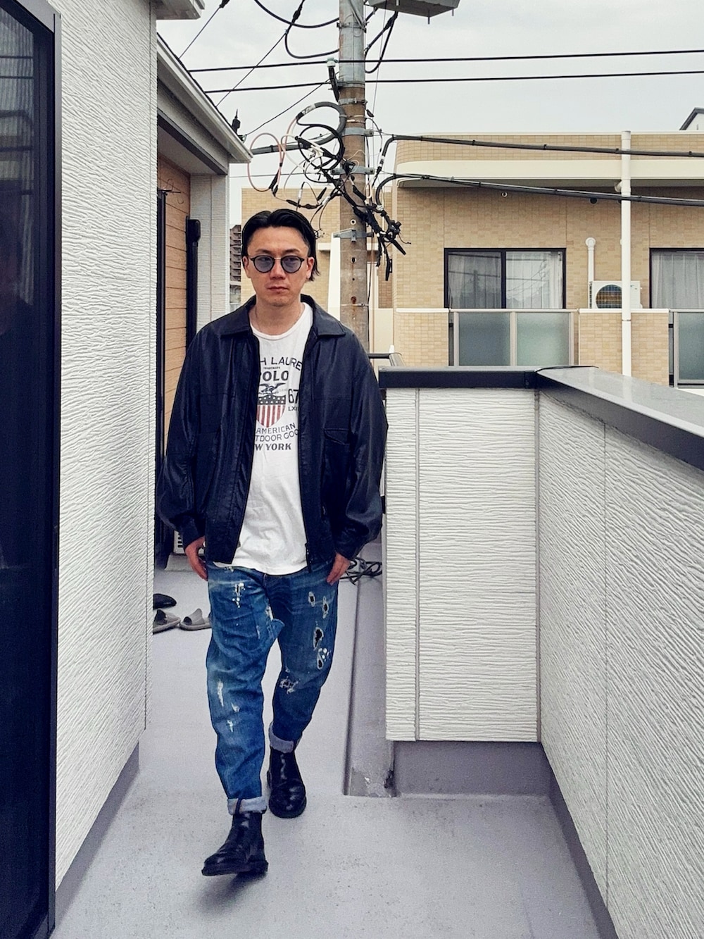 ブラック系のブルゾン、ブルー系のデニムパンツ、ホワイト系のTシャツ/カットソーを着用したメンズの春コーディネートの3枚目の写真