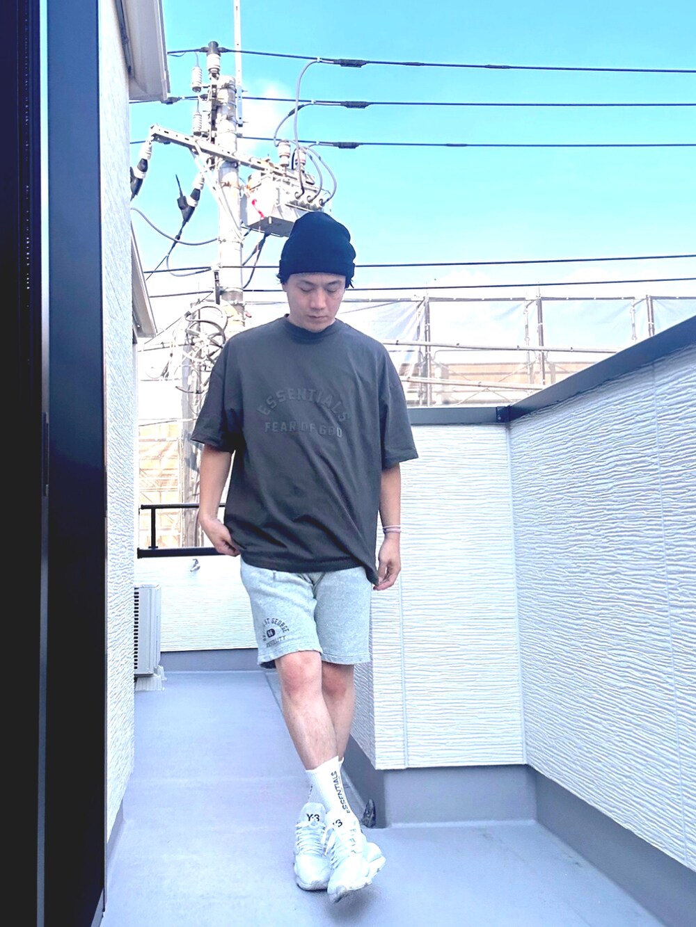 ブラック系のTシャツ/カットソー、グレー系のパンツ、ホワイト系のスニーカーを着用したメンズの夏コーディネートの2枚目の写真
