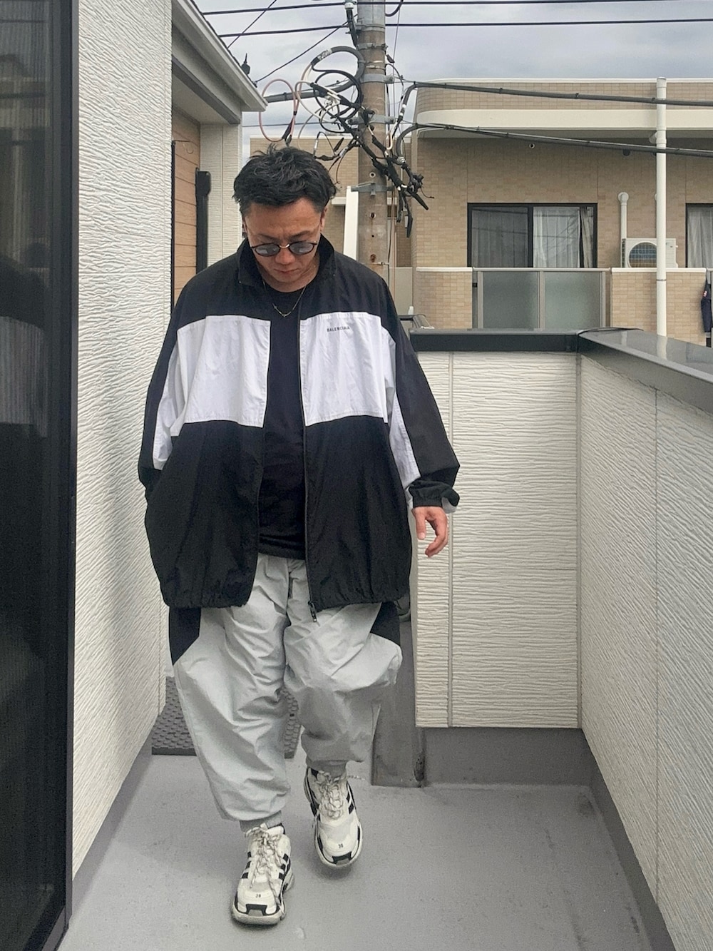 グレー系のその他パンツ、ブラック系のTシャツ/カットソー、ブラック系のナイロンジャケットを着用したメンズの秋コーディネートの3枚目の写真