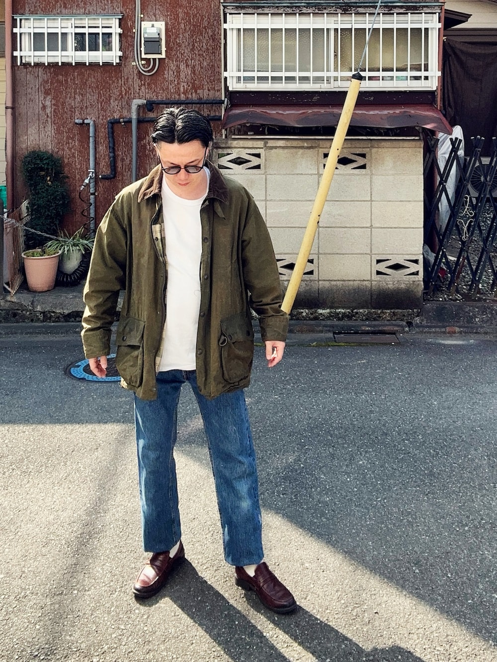 ブルー系のデニムパンツ、ホワイト系のTシャツ/カットソー、グリーン系のジャケット/アウターを着用したメンズの春コーディネートの3枚目の写真