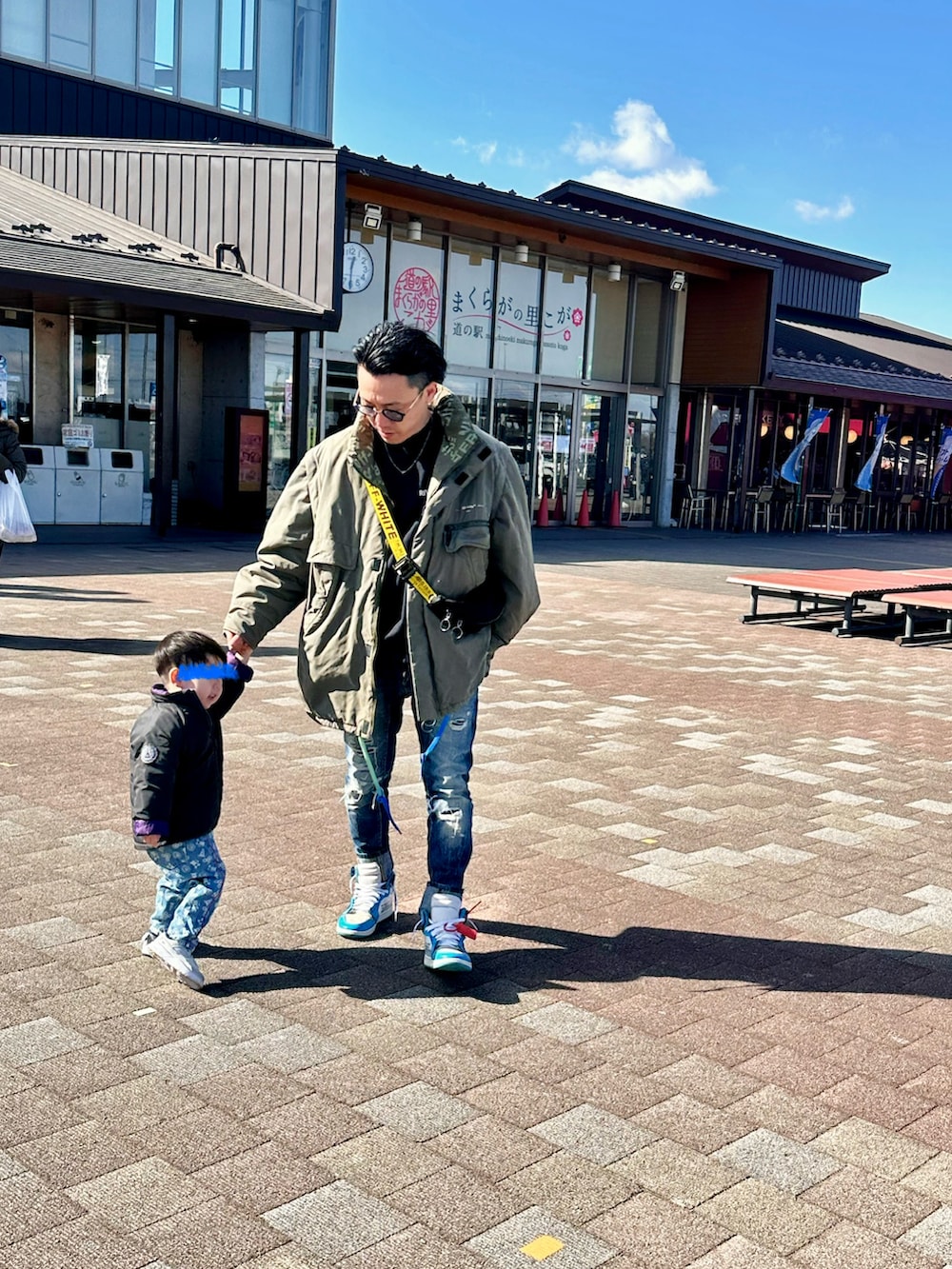 ブルー系のデニムパンツ、ブラック系のショルダーバッグ、ブラック系のスウェットを着用したメンズの冬コーディネートの3枚目の写真