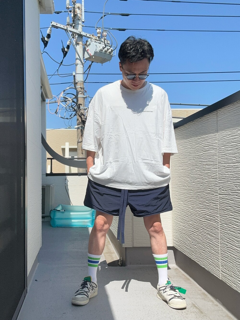 ホワイト系のTシャツ/カットソー、ブルー系のパンツ、ホワイト系のスニーカーを着用したメンズの夏コーディネートの4枚目の写真