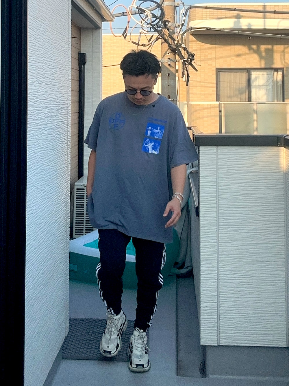 ブラック系のスウェットパンツ、ブルー系のTシャツ/カットソー、ホワイト系のシューズを着用したメンズの夏コーディネートの2枚目の写真