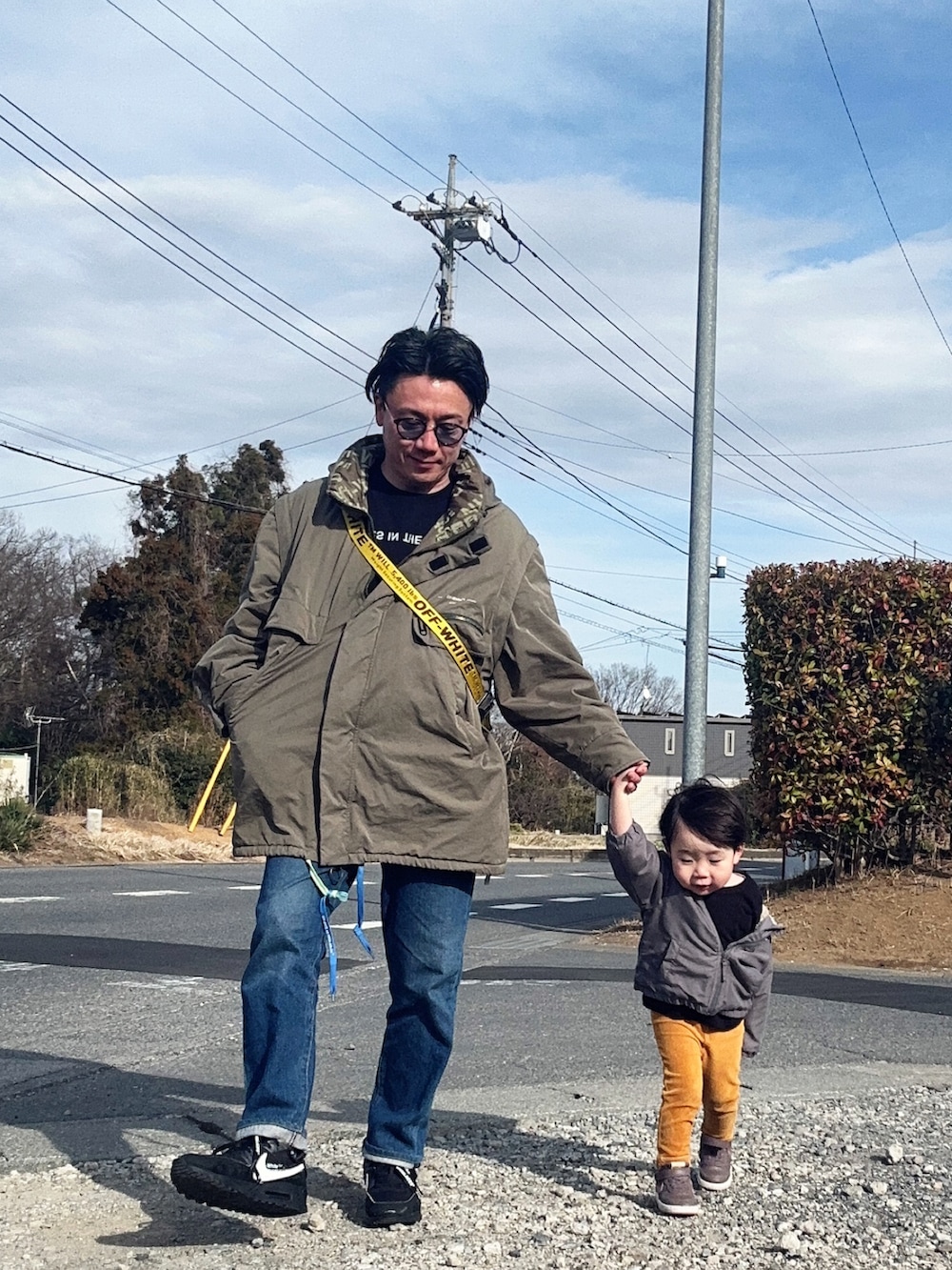 ブラック系のTシャツ/カットソー、ブルー系のデニムパンツ、ブラック系のショルダーバッグを着用したメンズの春コーディネートの3枚目の写真