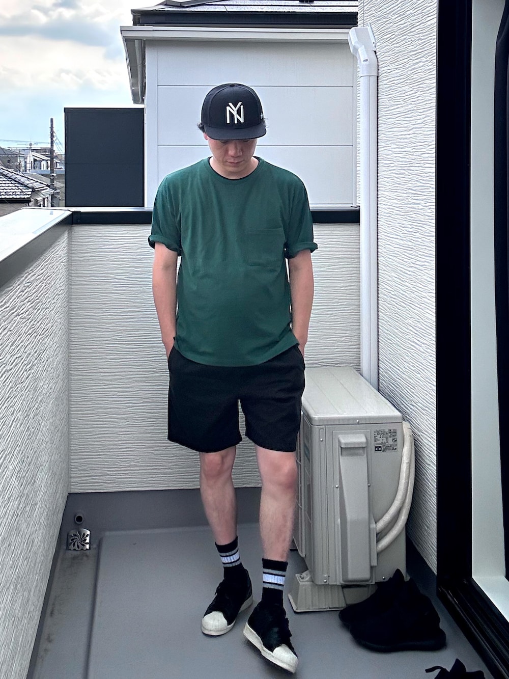 ブラック系のスニーカー、ブラック系のパンツ、グリーン系のTシャツ/カットソーを着用したメンズの夏コーディネートの2枚目の写真