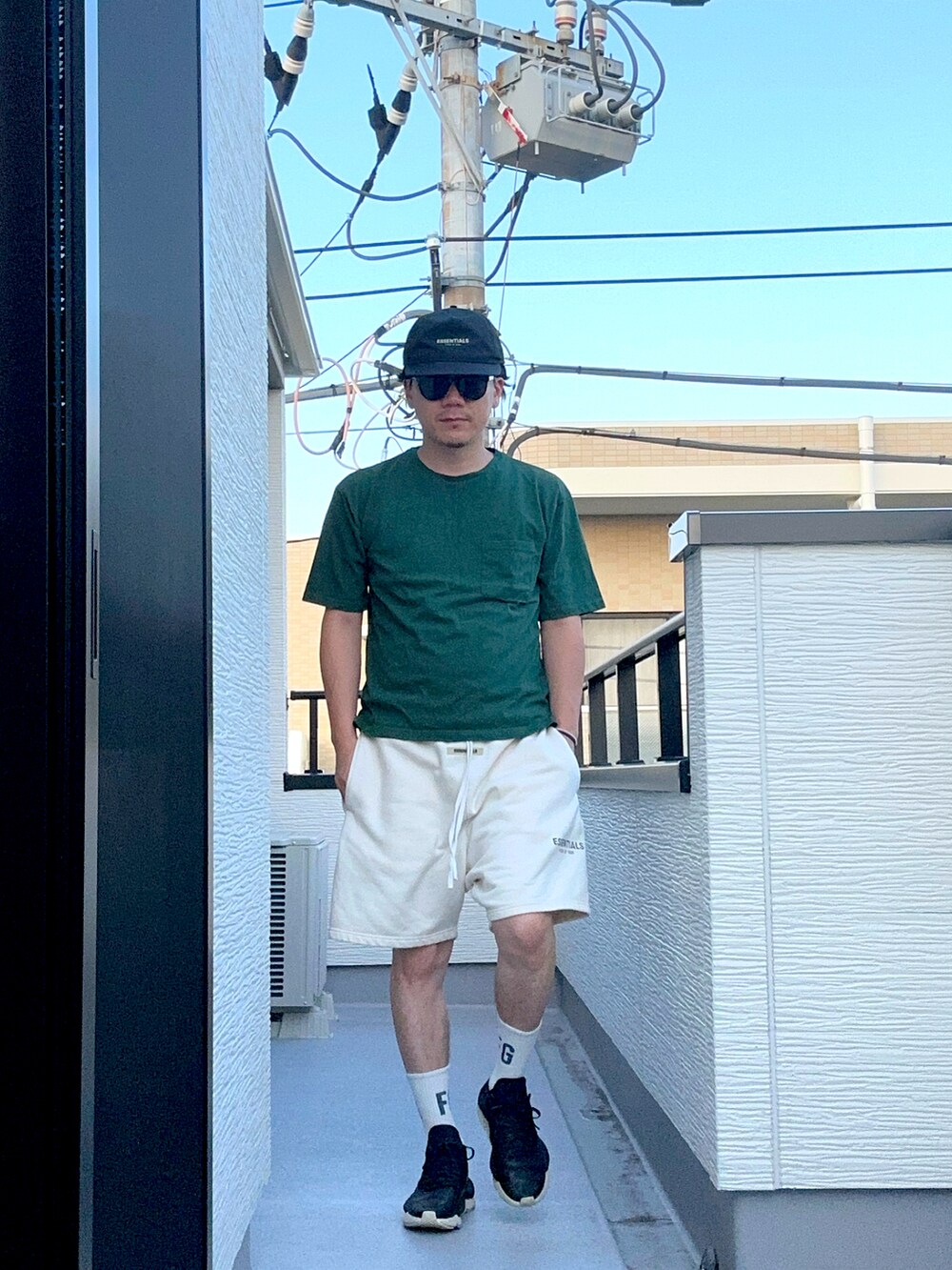 グリーン系のTシャツ/カットソー、ホワイト系のスウェットパンツ、ブラック系のスニーカーを着用したメンズの夏コーディネートの4枚目の写真