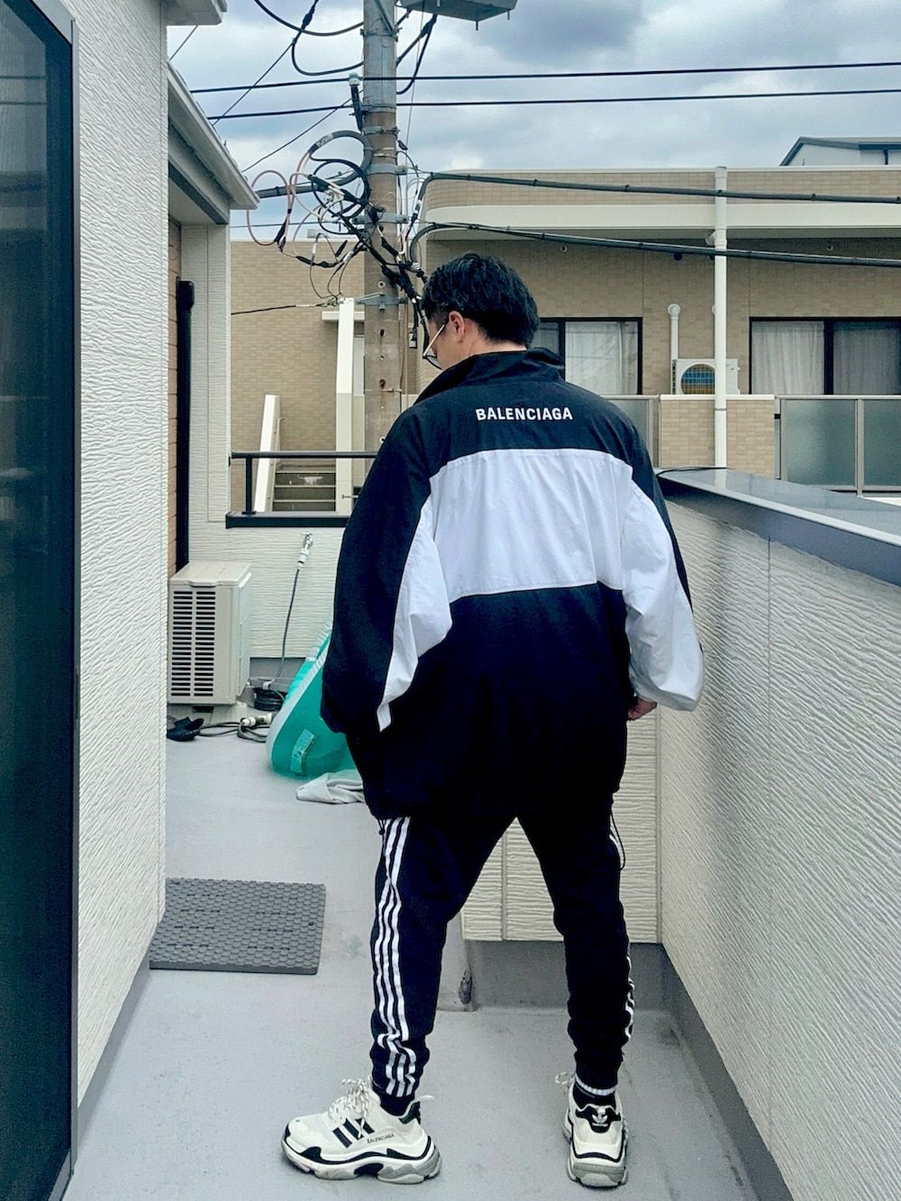 ブラック系のスウェットパンツ、ホワイト系のTシャツ/カットソー、ブラック系のナイロンジャケットを着用したメンズの秋コーディネートの4枚目の写真