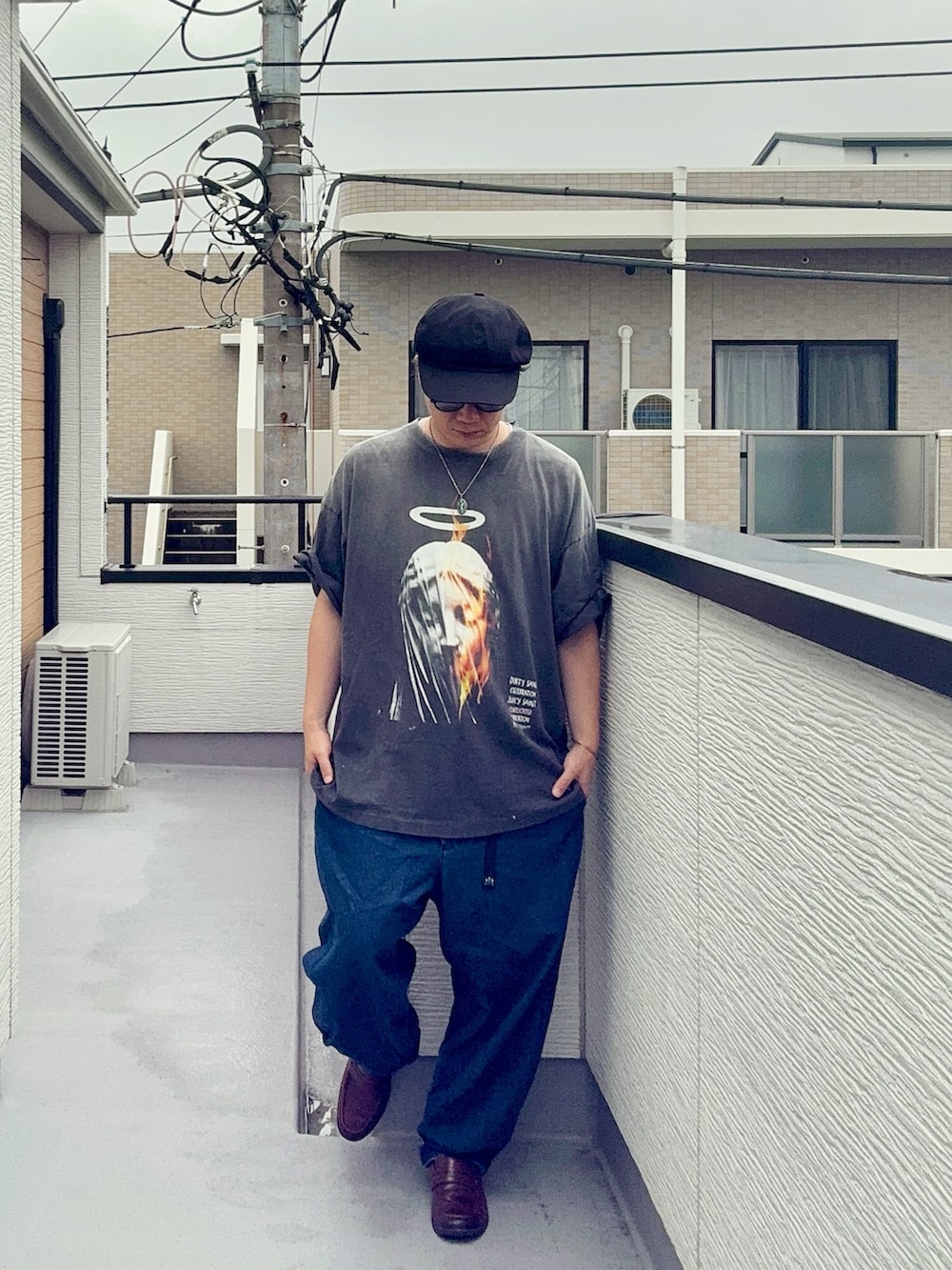 ブルー系のデニムパンツ、ブラック系のTシャツ/カットソー、ブラウン系のローファーを着用したメンズの夏コーディネートの3枚目の写真