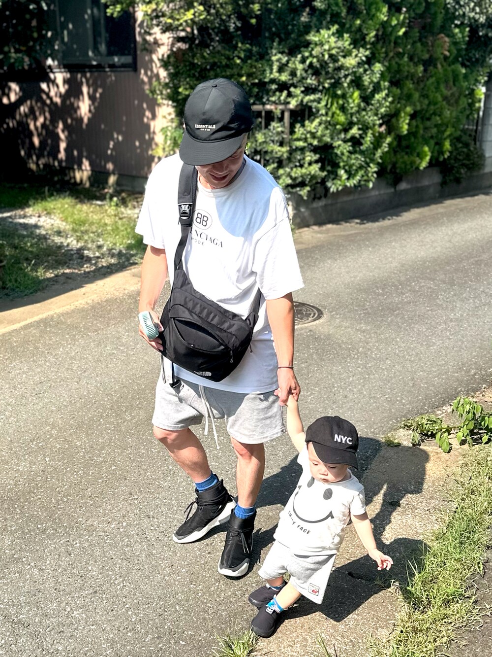 ブラック系のショルダーバッグ、ホワイト系のその他トップス、ホワイト系のTシャツ/カットソーを着用したメンズの夏コーディネートの3枚目の写真