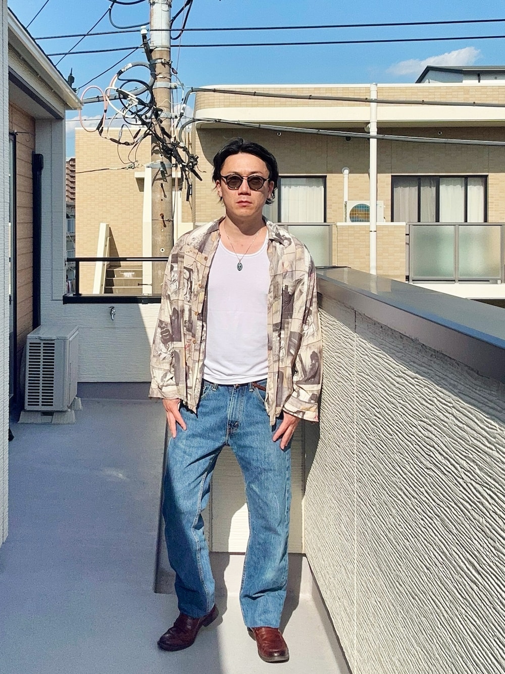 ブルー系のデニムパンツ、ホワイト系のタンクトップ、ベージュ系のシャツ/ブラウスを着用したメンズの春コーディネートの2枚目の写真