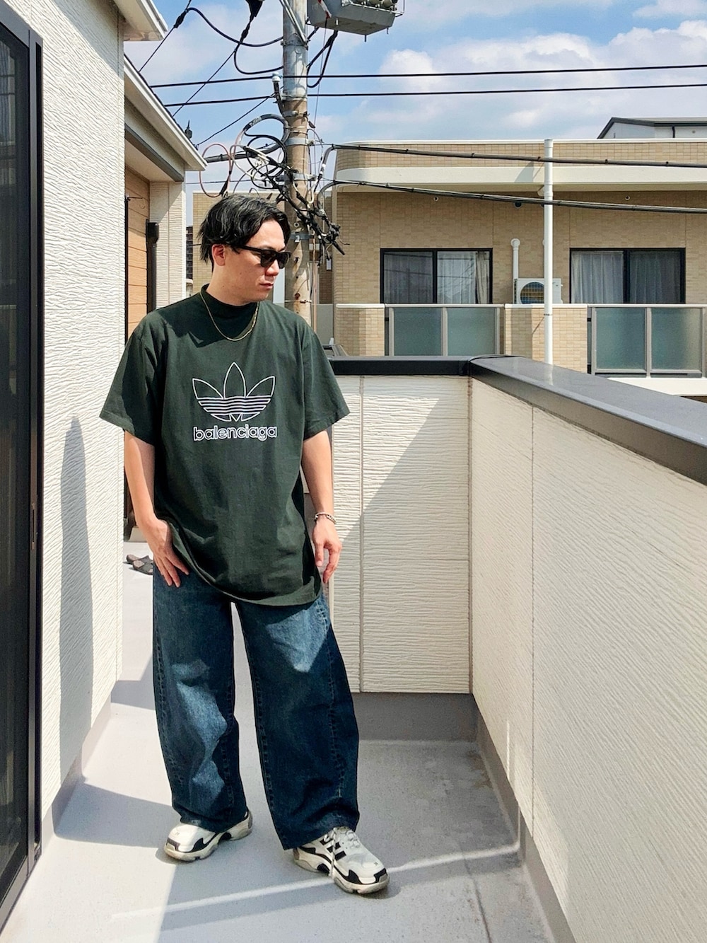 グリーン系のTシャツ/カットソー、ブルー系のデニムパンツ、ホワイト系のシューズを着用したメンズの秋コーディネートの2枚目の写真